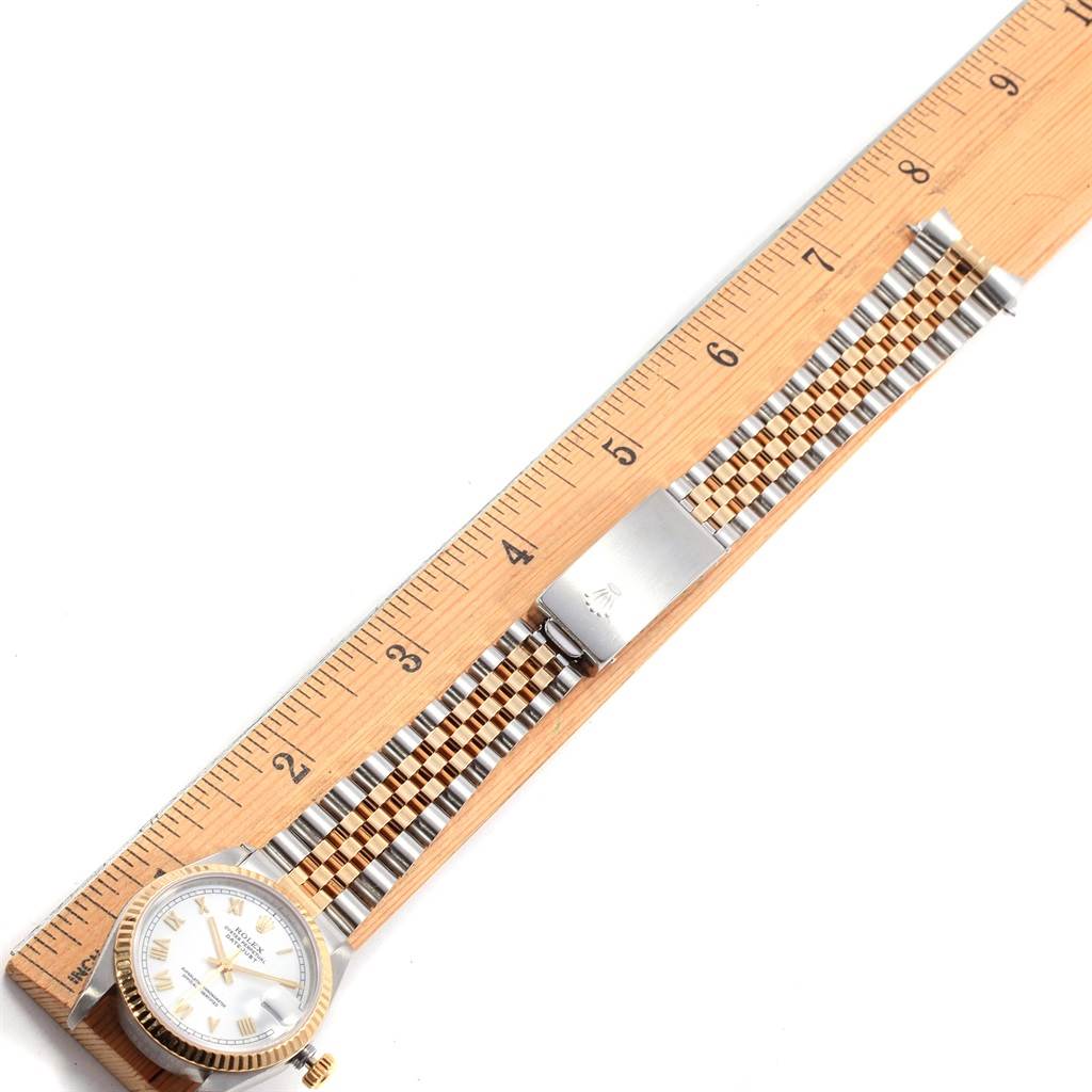 The Rolex Mid-Size 68273 Women's Steel and Gold (two tone) White Dial 68273 Women's Steel and Gold (two tone) White Dial watch is shown lying flat, with detailed views of the face, bezel, and bracelet against a wooden ruler for scale.