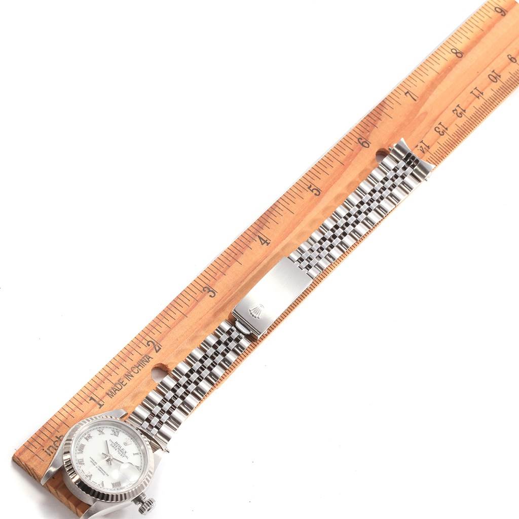 The image shows a Rolex Mid-Size 69174 Women's Stainless Steel White Dial 69174 Women's Stainless Steel White Dial watch placed next to a ruler, displaying its face, bracelet, and clasp.