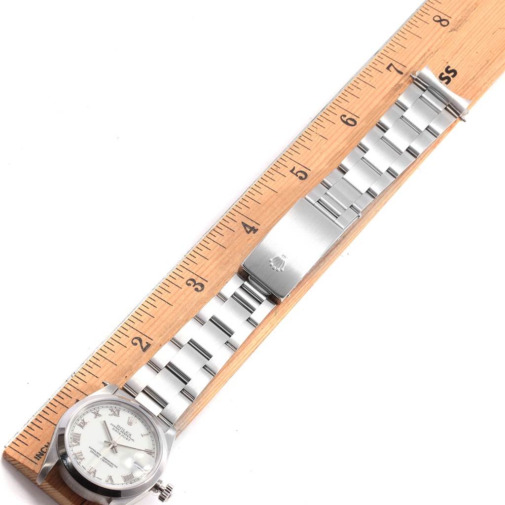 The image shows a Rolex Mid-Size 68240 Women's Stainless Steel White Dial 68240 Women's Stainless Steel White Dial model watch measuring approximately 6.5 inches using a wooden ruler.