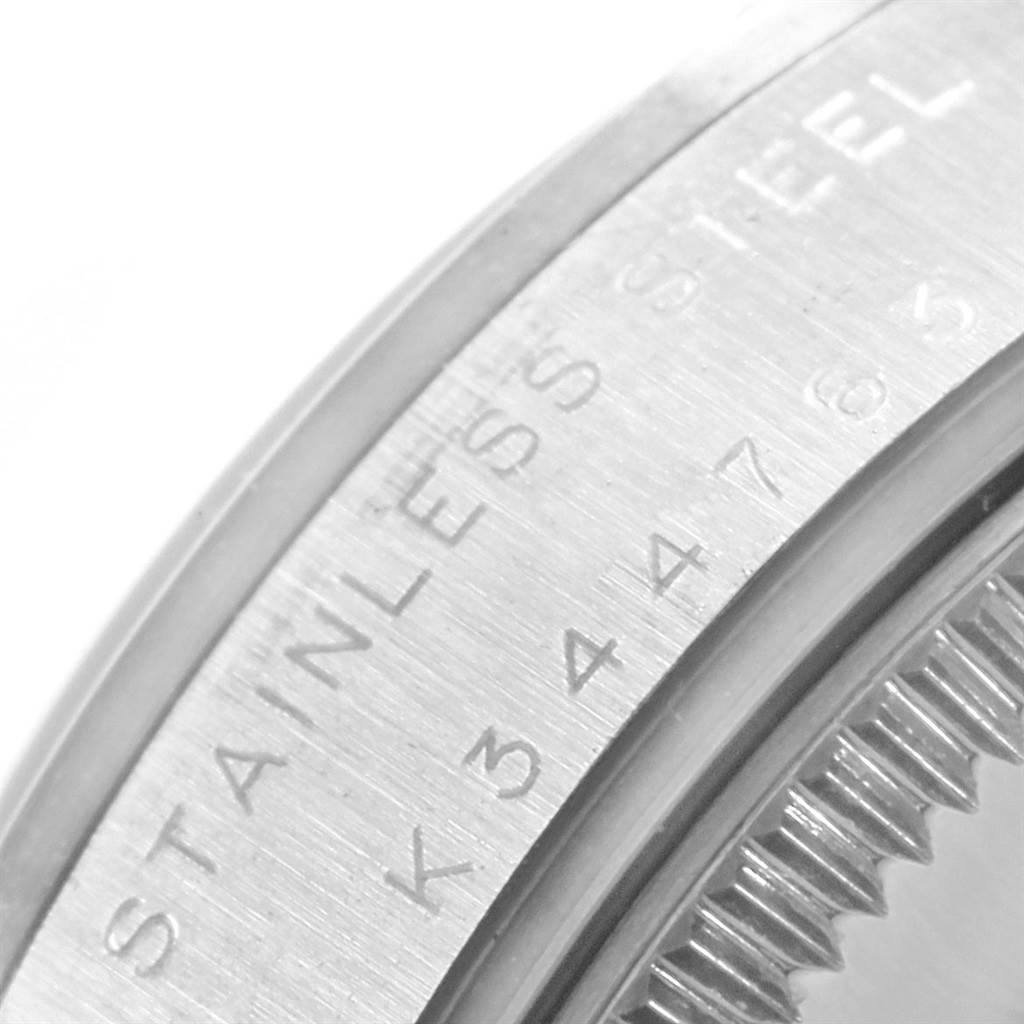 This close-up angle shows the engraved case back and part of the ridged bezel of a Mid-Size Rolex watch.