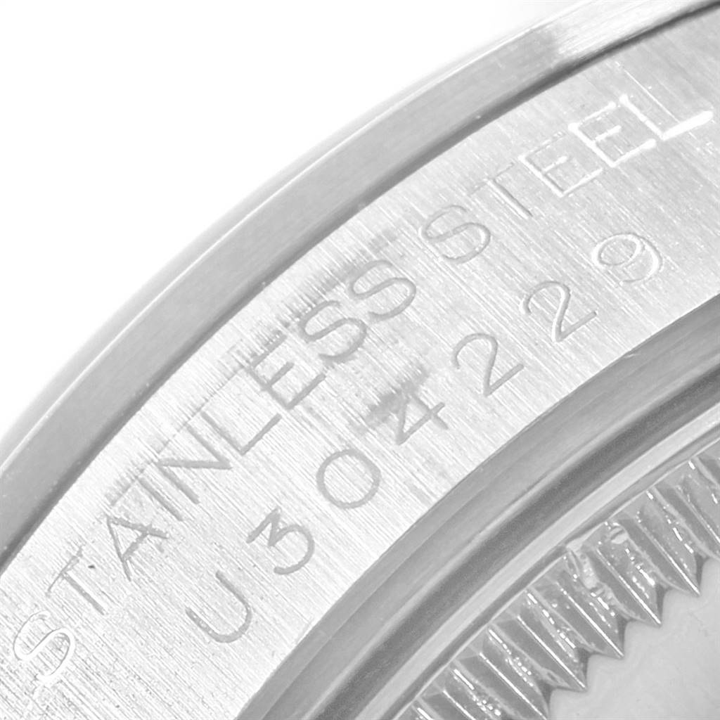 This image shows a close-up of the steel case back of a Mid-Size Rolex watch, highlighting the engraved serial number.