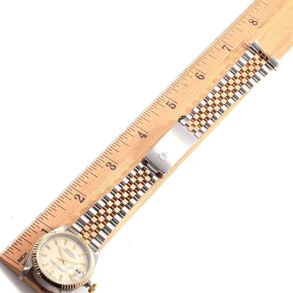This image shows a Rolex Mid-Size 68273 Women
s Steel and Gold (two tone) Beige Dial 68273 Women
s Steel and Gold (two tone) Beige Dial watch laid flat next to a ruler, displaying the full bracelet and watch face from an overhead angle.