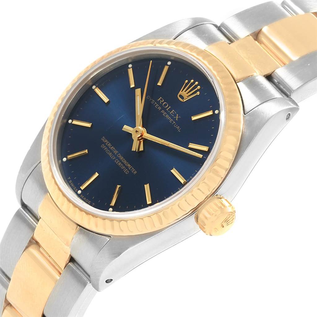 The image shows a Rolex Mid-Size 67513 Women's Steel and Gold (two tone) Blue Dial 67513 Women's Steel and Gold (two tone) Blue Dial model watch at an angle highlighting the dial, bezel, crown, and part of the bracelet.