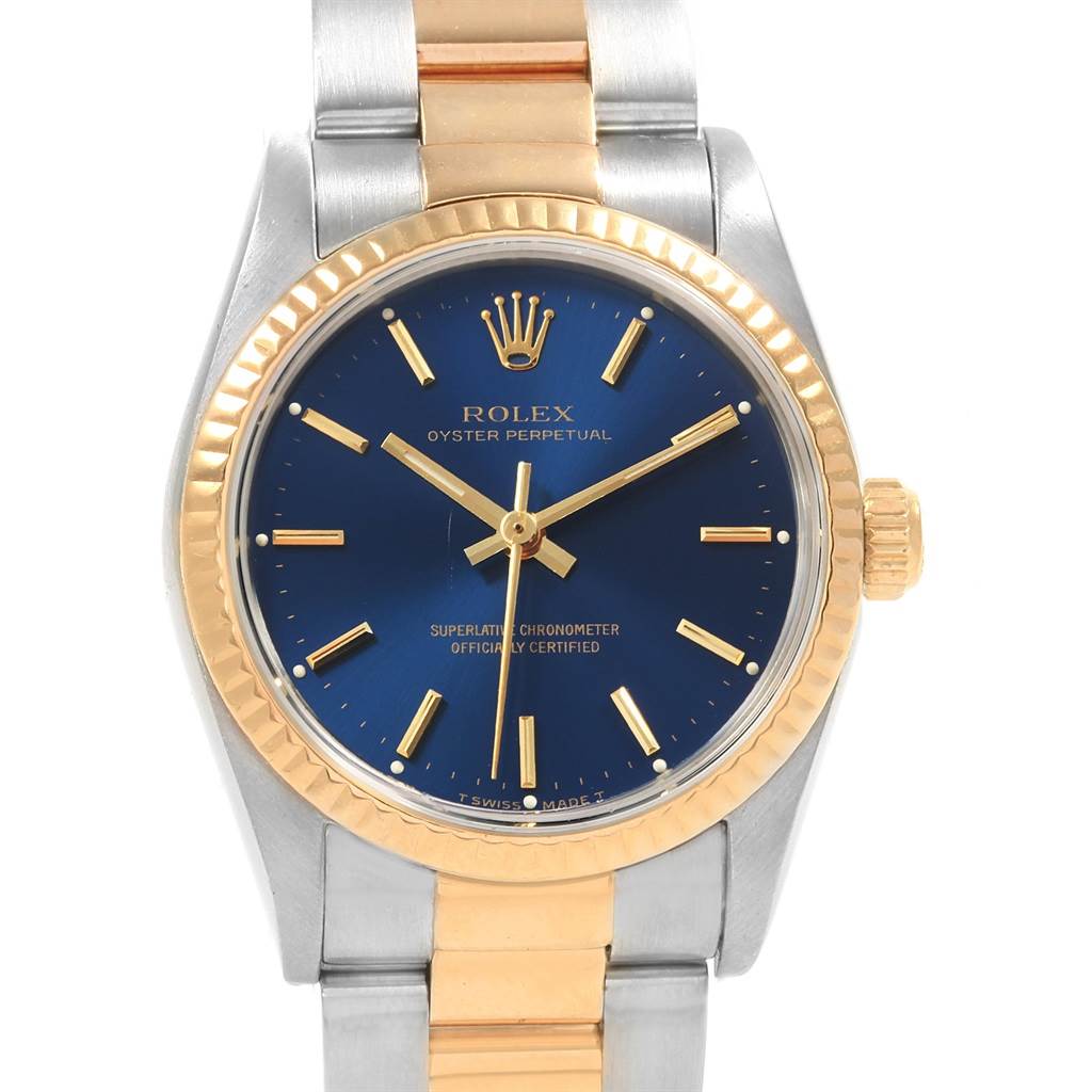This Rolex Mid-Size 67513 Women's Steel and Gold (two tone) Blue Dial 67513 Women's Steel and Gold (two tone) Blue Dial Oyster Perpetual watch is shown from a front angle, highlighting its blue dial, gold bezel, and two-tone bracelet.