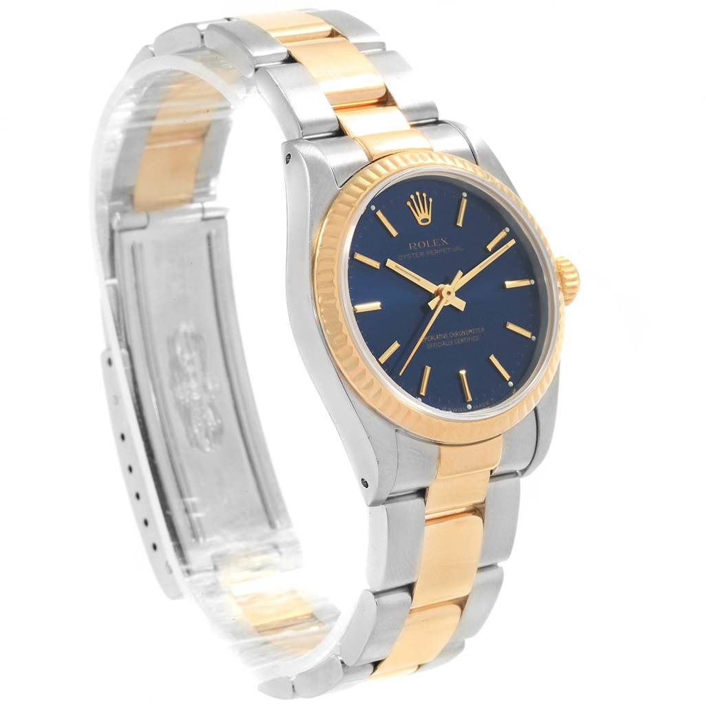 This image shows a Rolex Mid-Size 67513 Women's Steel and Gold (two tone) Blue Dial 67513 Women's Steel and Gold (two tone) Blue Dial model watch at an angled view highlighting its blue dial, gold bezel, and two-tone bracelet.
