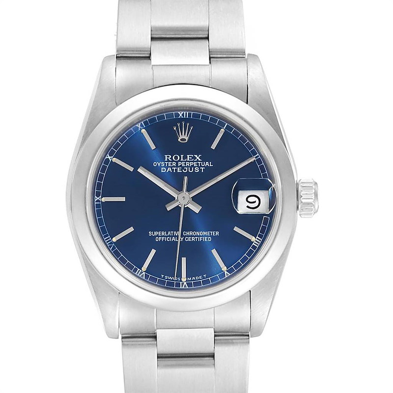 The image depicts a front view of a Rolex Mid-Size Datejust watch, highlighting its blue dial, date window, and silver bracelet.