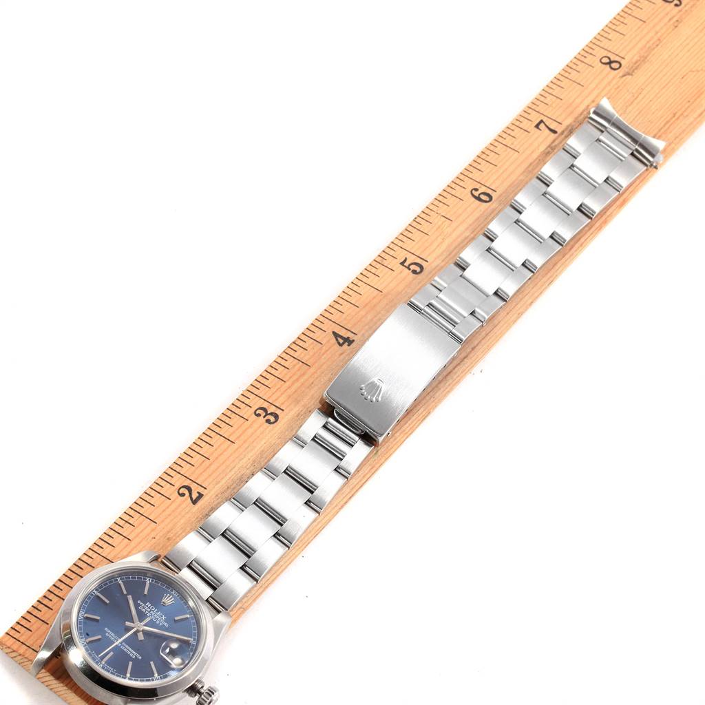 This image shows a Rolex Mid-Size 68240 Women's Stainless Steel Blue Dial 68240 Women's Stainless Steel Blue Dial watch laid flat alongside a ruler, displaying the face, bracelet, and clasp.
