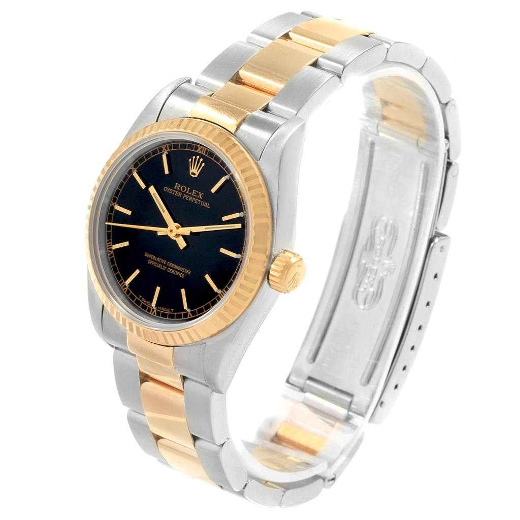 This image shows a Rolex Mid-Size 67513 Women's Steel and Gold (two tone) Black Dial 67513 Women's Steel and Gold (two tone) Black Dial Oyster Perpetual watch from a side angle, highlighting the black dial, fluted bezel, and two-tone bracelet.