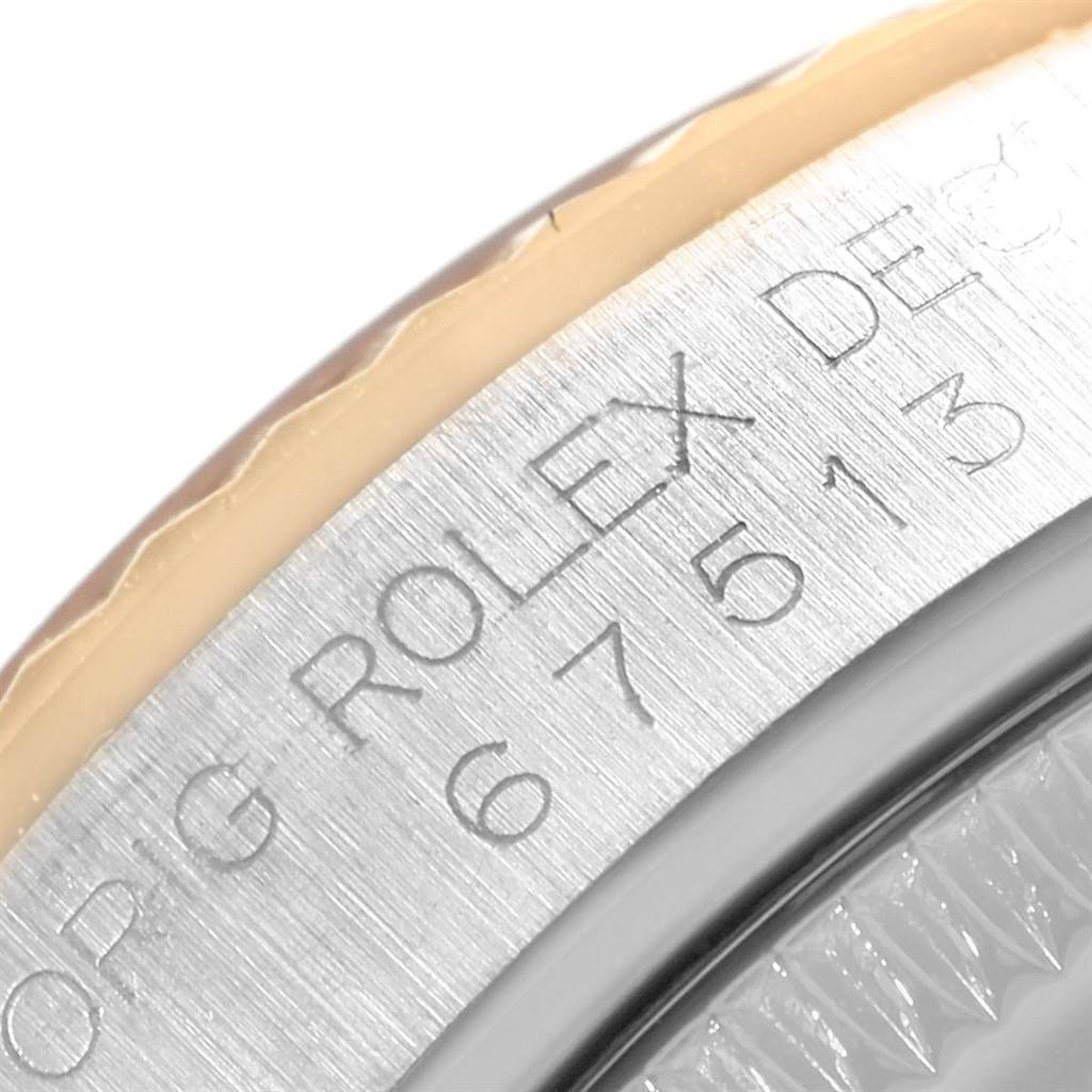The image shows a close-up of the etched bezel and part of the crystal of a mid-size Rolex watch.
