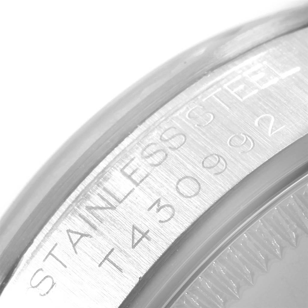 The image shows a close-up of the bezel and case side with engraved text on a Mid-Size Rolex watch.