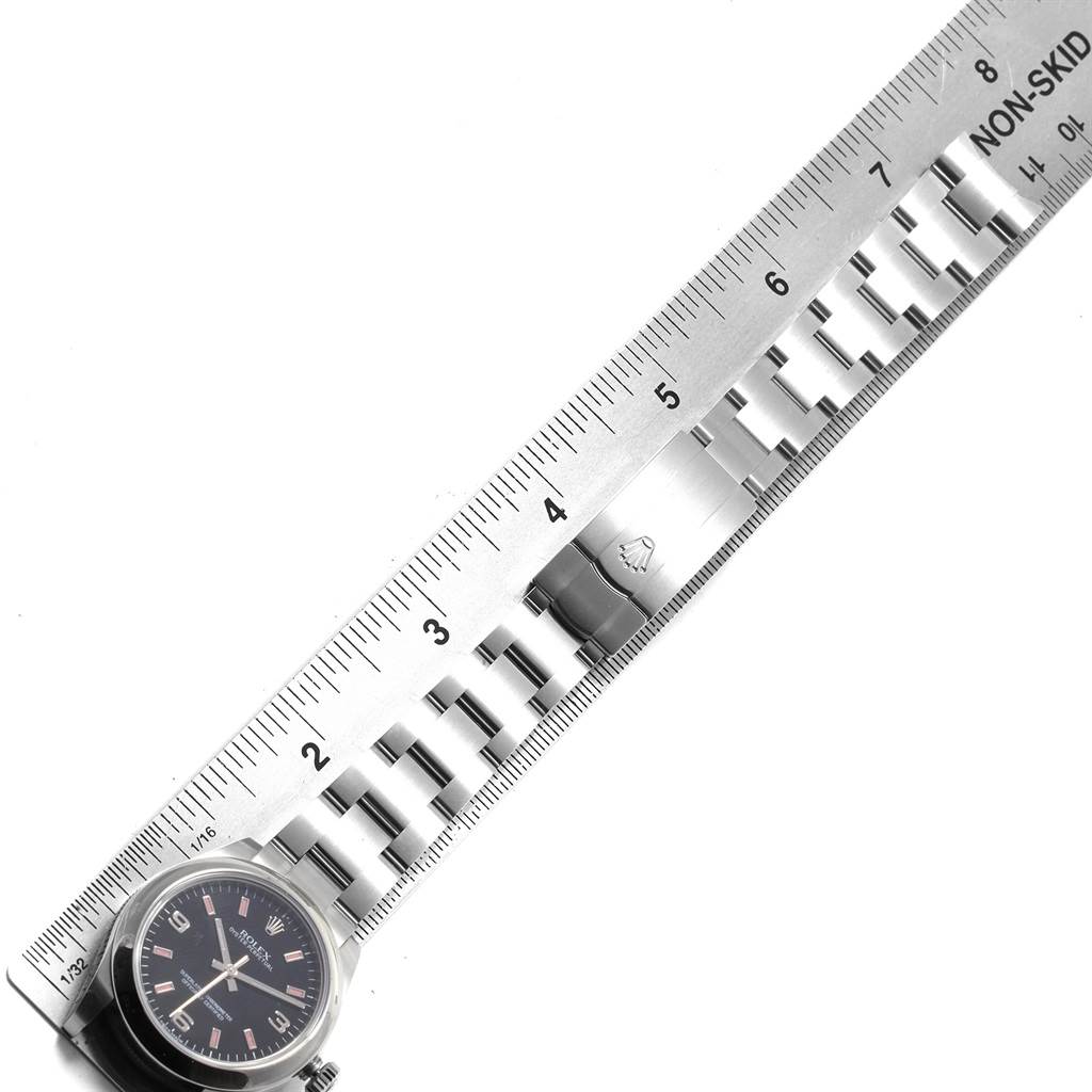 The image shows a top-down view of a Mid-Size Rolex watch with a ruler measuring the metallic watch band.