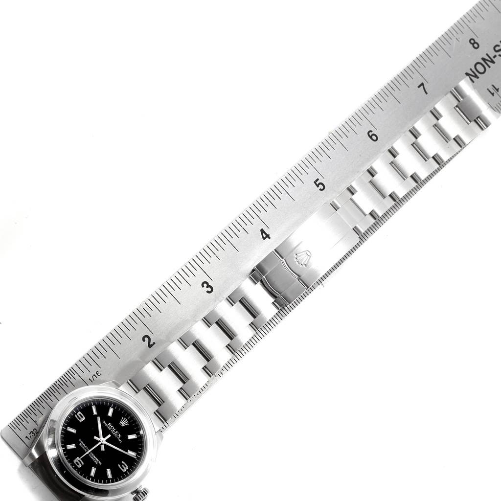 The image shows a top-down view of a Mid-Size Rolex watch, featuring the face and partial bracelet placed alongside a ruler for measurement.