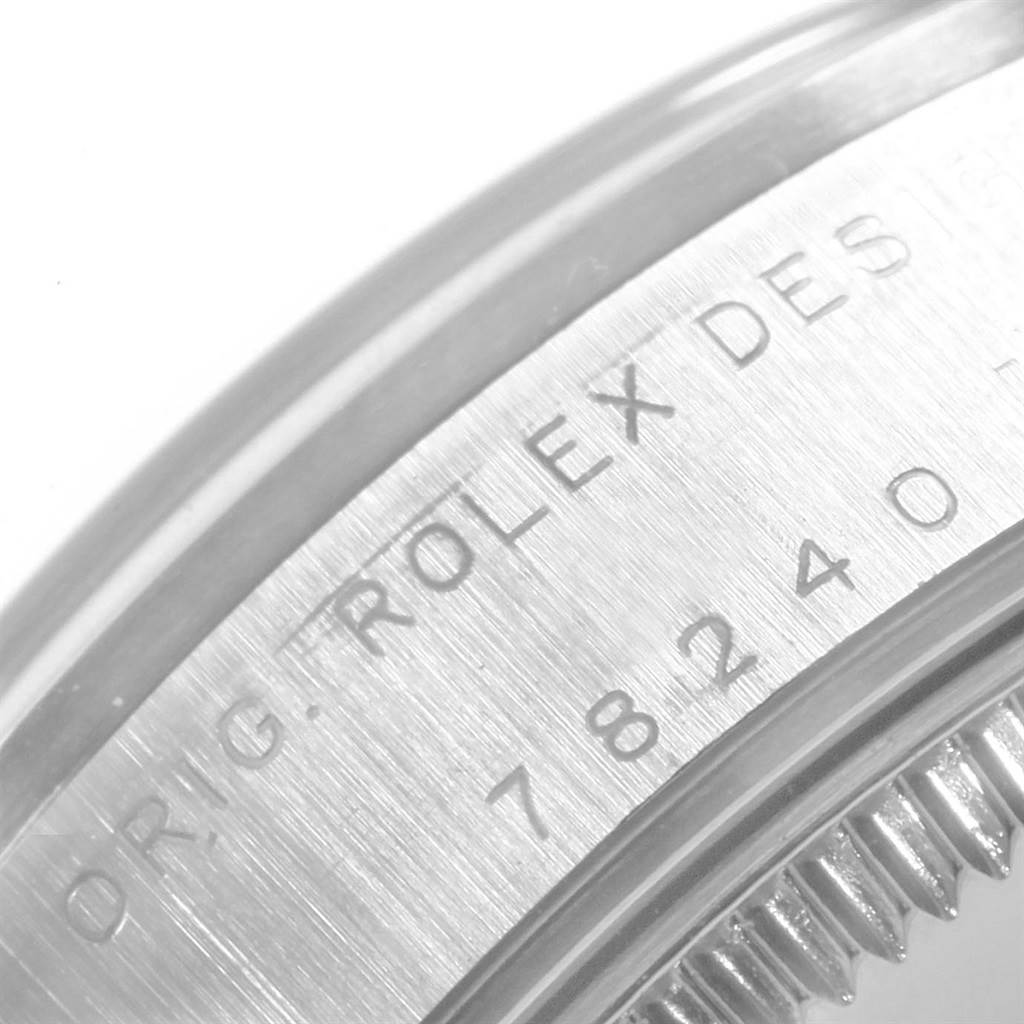 The image shows a close-up of the side engraving and bezel teeth on a Mid-Size Rolex watch.