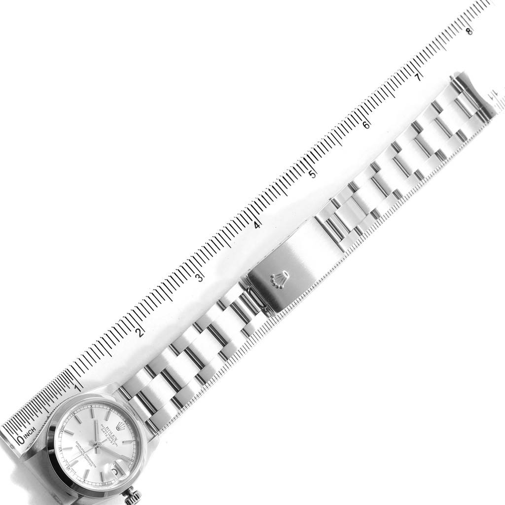 The image shows a Mid-Size Rolex watch and its bracelet laid flat alongside a ruler for measurement.
