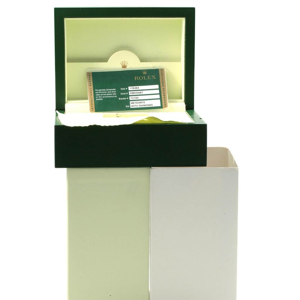 The image shows an open Rolex box with a card displaying information about a Mid-Size model Rolex watch.