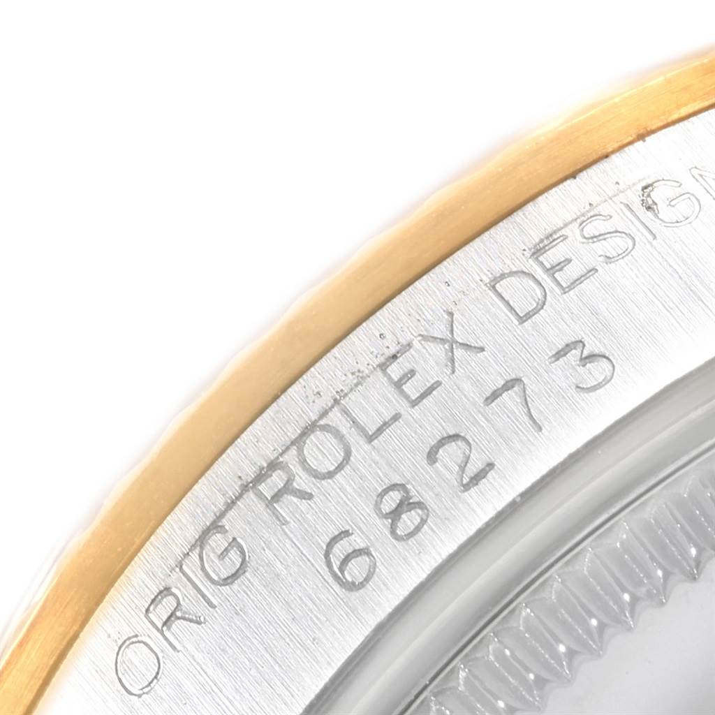 This image shows a close-up of the bezel and case side of a Mid-Size Rolex watch, featuring engraved text.