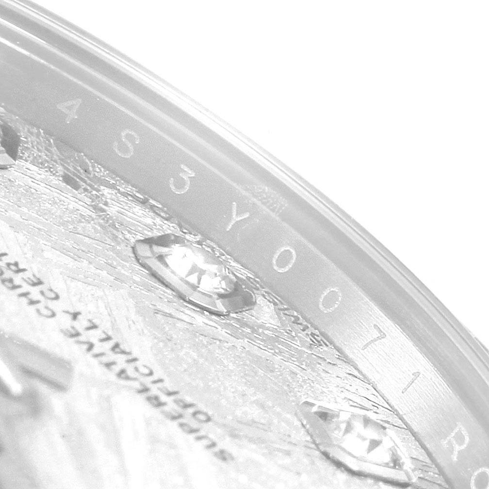This image shows a close-up of the bezel and part of the dial of a Mid-Size Rolex watch, highlighting the serial number and diamond markers.