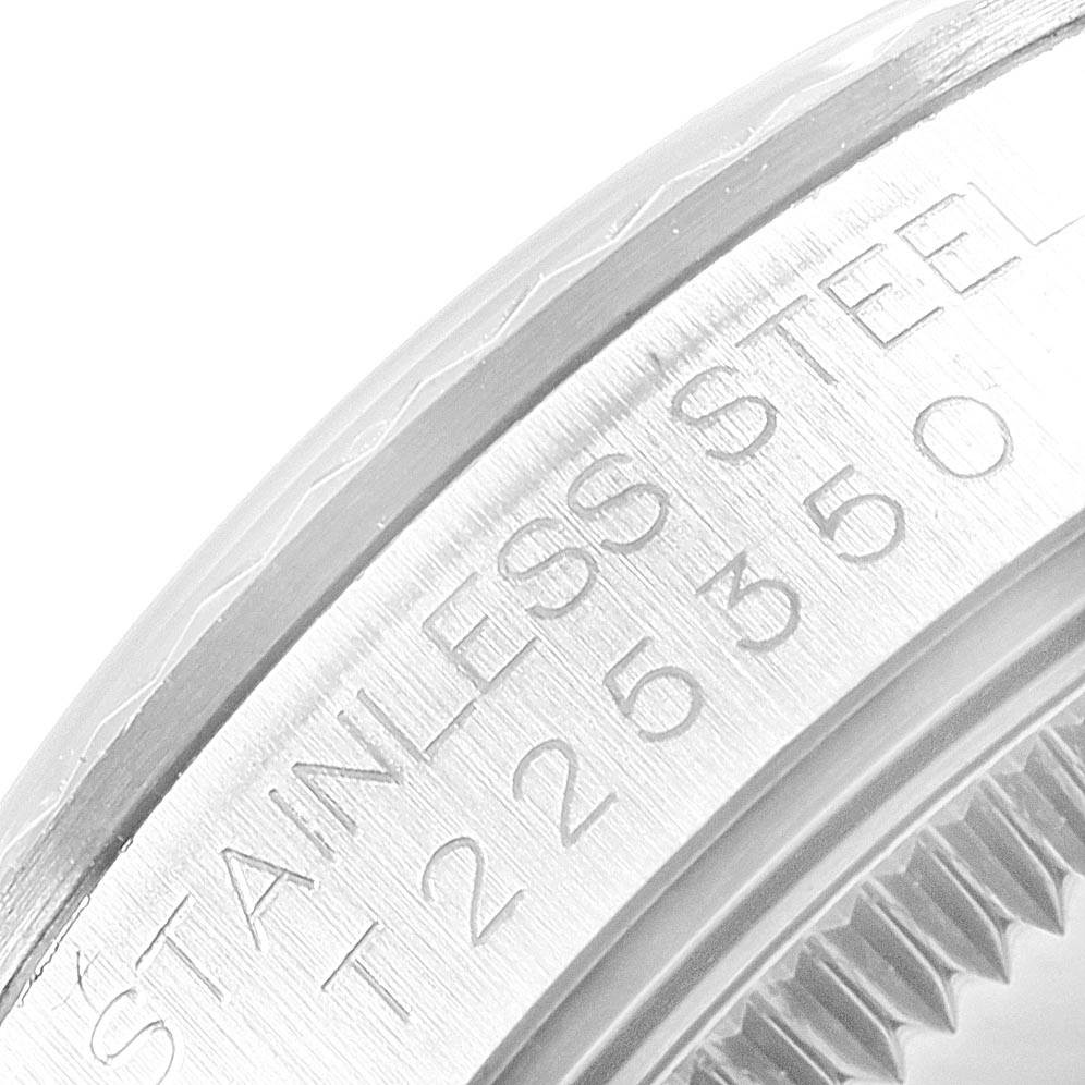 The image shows a close-up of the stainless steel bezel with engraved text on a Mid-Size Rolex watch.