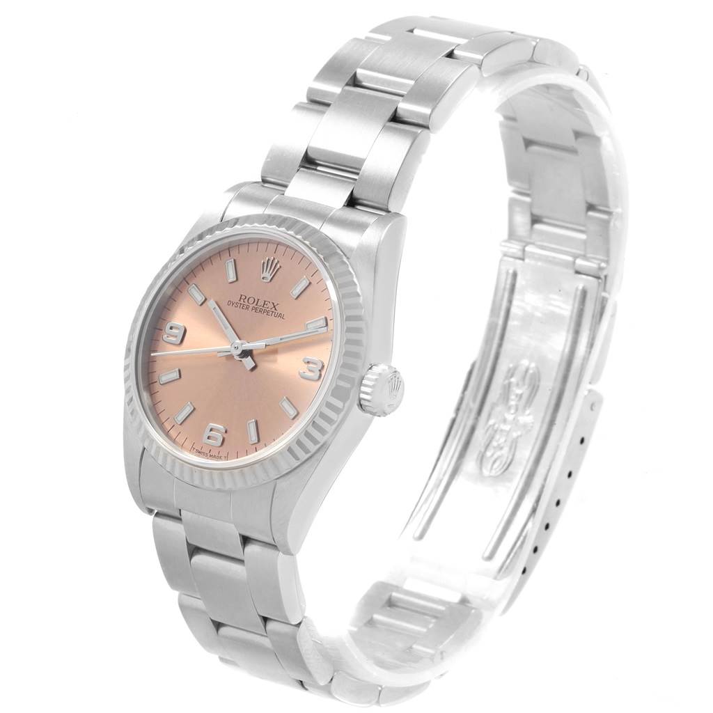 The image shows a Rolex Mid-Size 67514 Women
s Stainless Steel Pink Dial 67514 Women
s Stainless Steel Pink Dial Oyster Perpetual watch angled from the front, revealing the dial, bezel, case, and a portion of the bracelet.