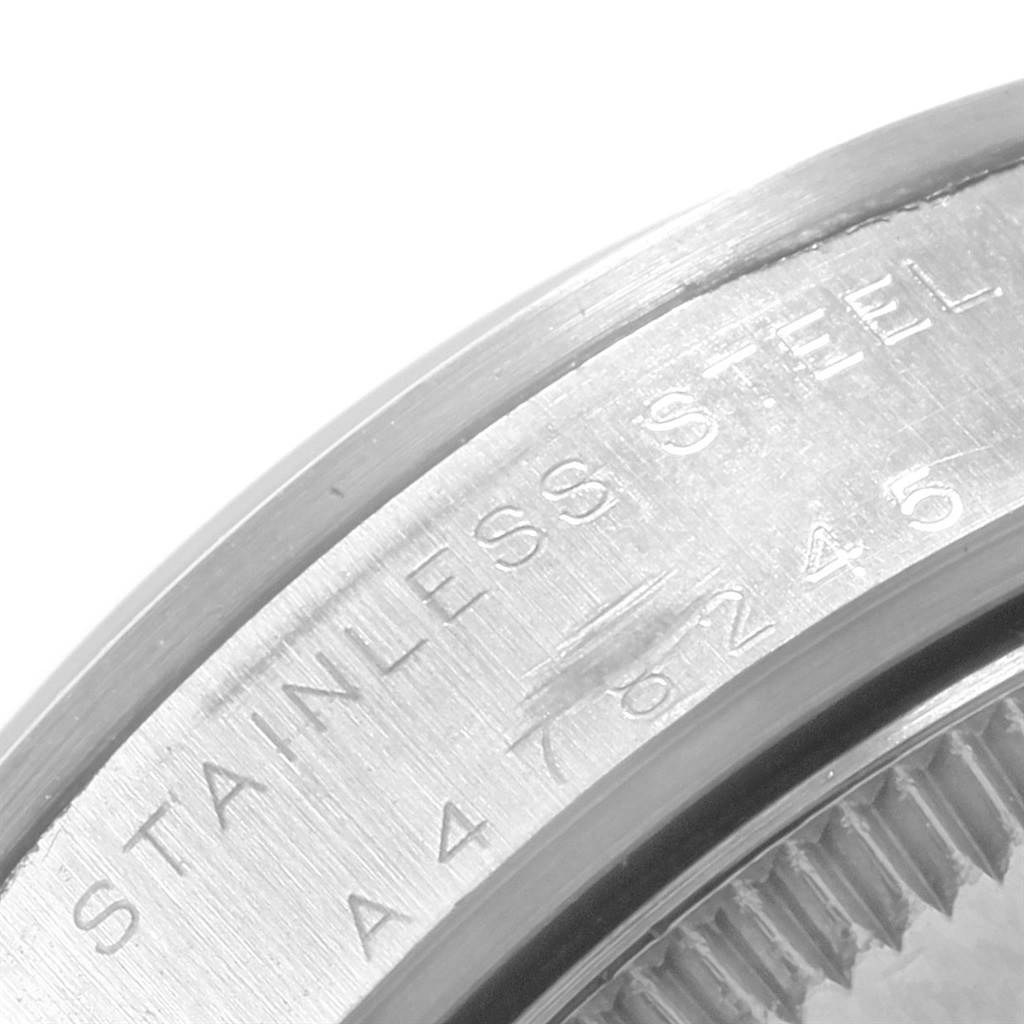 This image shows a close-up of the stainless steel casing and engraved serial number of a Mid-Size Rolex watch.