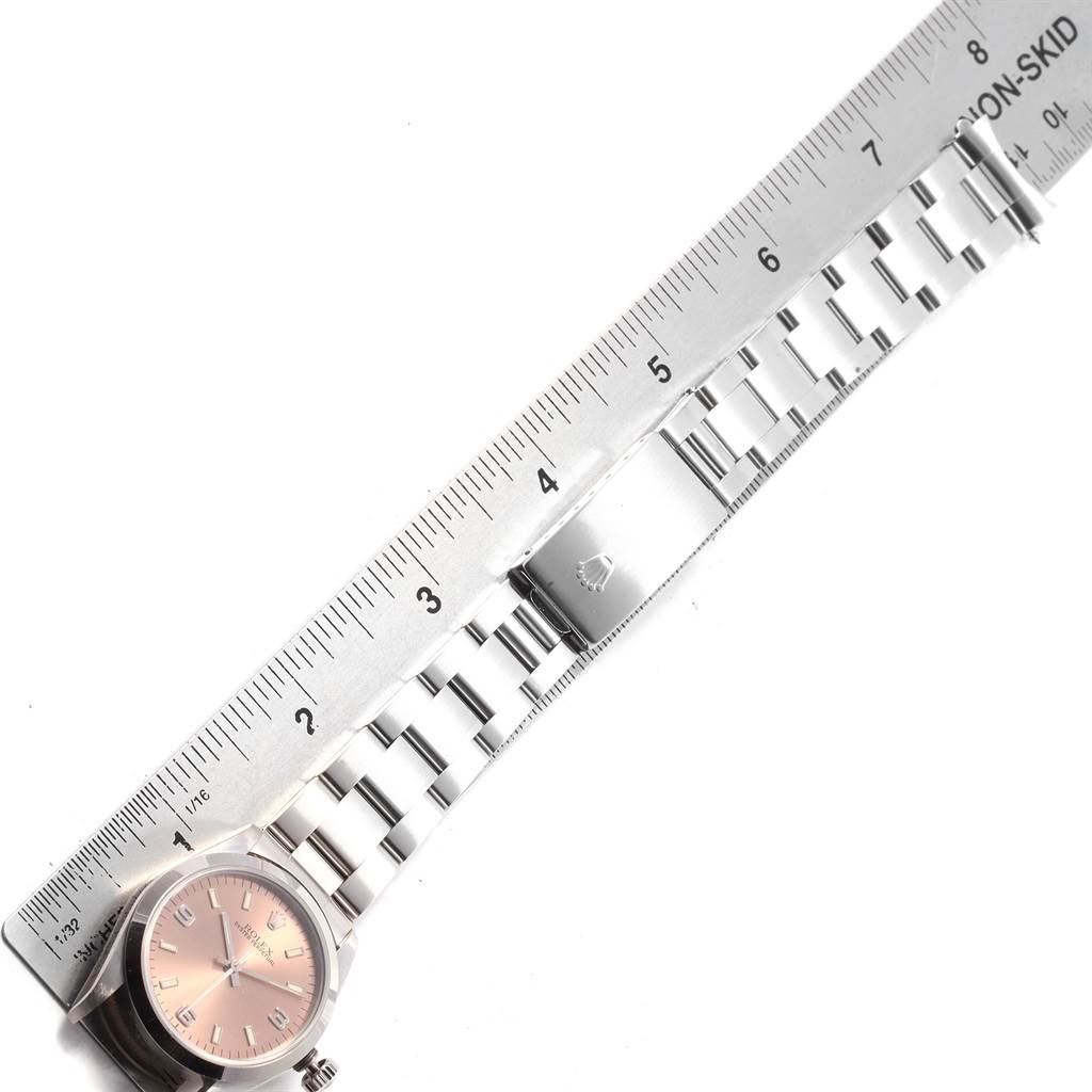 The image shows a top view of a Rolex Mid-Size 67480 Women's Stainless Steel Pink Dial 67480 Women's Stainless Steel Pink Dial model watch, displaying the watch face, bracelet, and a ruler for scale.
