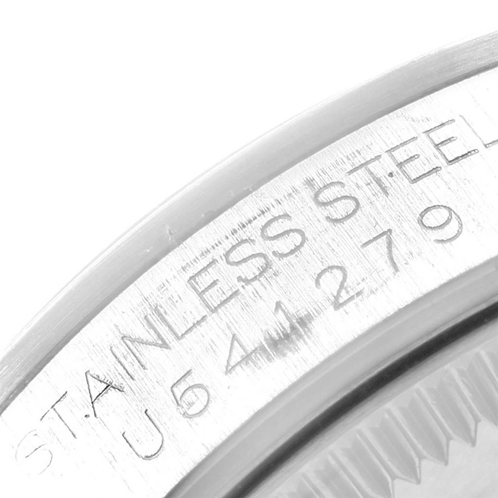 This image shows a close-up of the outer edge of a stainless steel Mid-Size Rolex watch, including part of the engraved serial number.