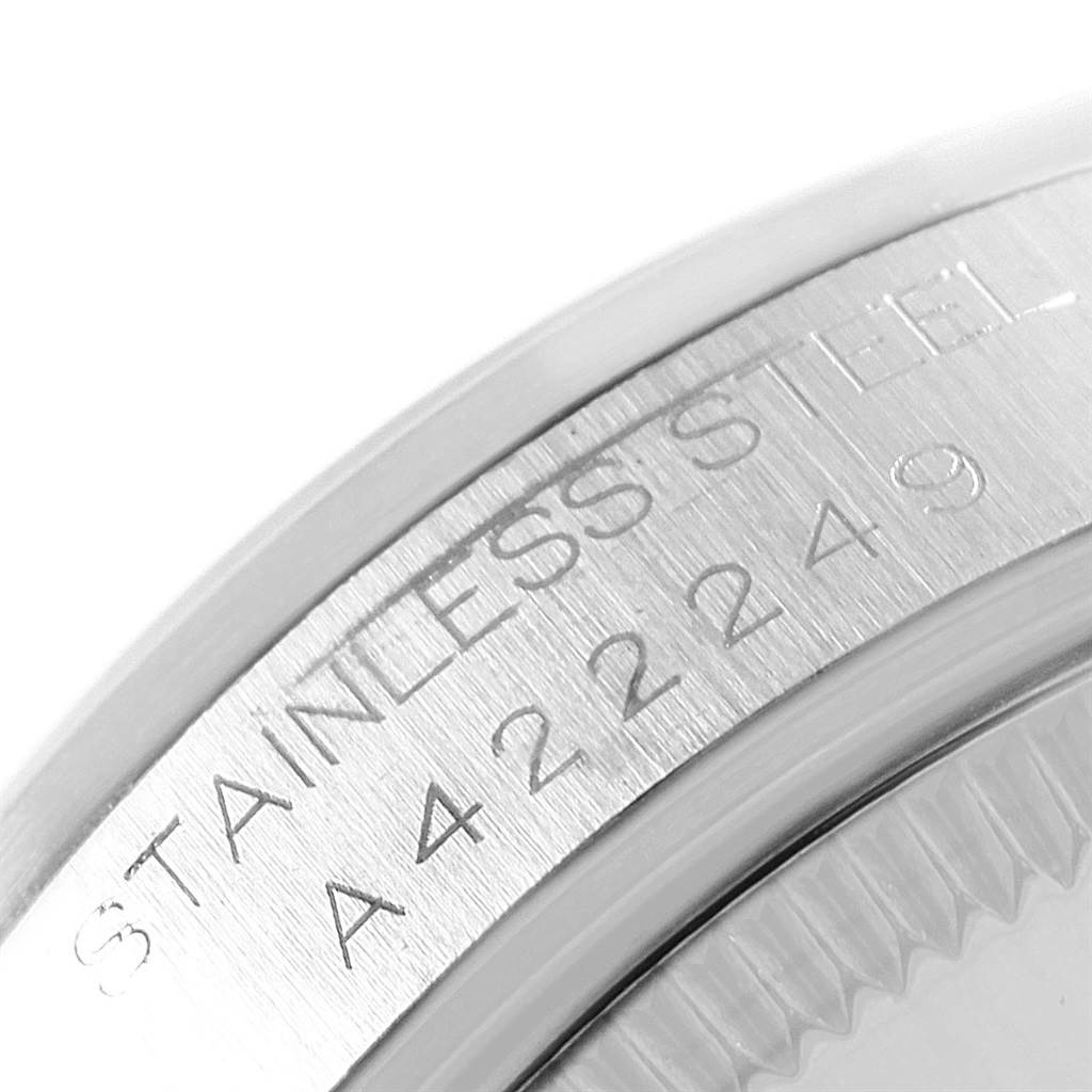 Close-up of the serial number engraving on the stainless steel case of a Mid-Size Rolex watch.