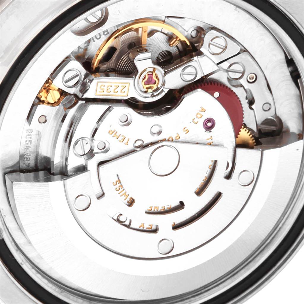 The image shows a close-up view of the movement mechanism of a Rolex Mid-Size 178384 Women's Stainless Steel Black Dial 178384 Women's Stainless Steel Black Dial watch, featuring gears and intricate components.