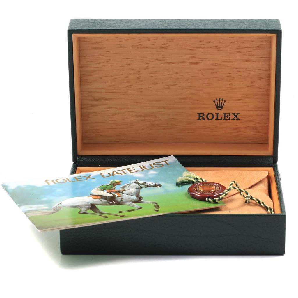 This image shows an open Rolex box with a Rolex Datejust booklet and a green and gold tag inside.