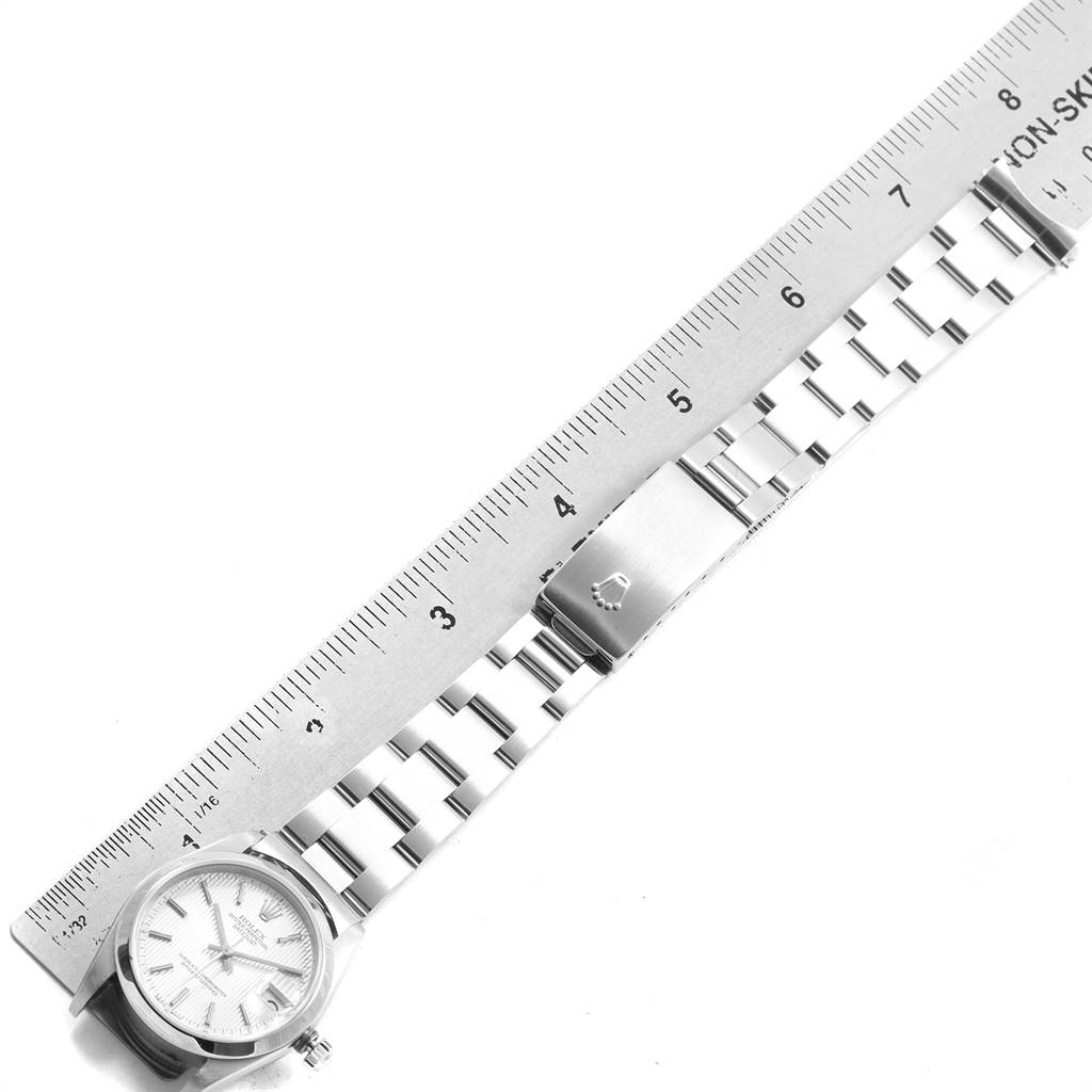The Rolex Mid-Size 78240 Women's Stainless Steel Silver Dial 78240 Women's Stainless Steel Silver Dial model watch is shown laid flat with a ruler measuring its length, displaying the face and metal bracelet.
