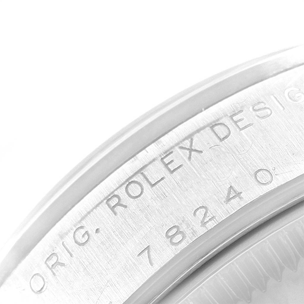 This image shows a close-up of the sides and rim of the casing for a Rolex Mid-Size 78240 Women's Stainless Steel Silver Dial 78240 Women's Stainless Steel Silver Dial model, featuring an engraved serial number.