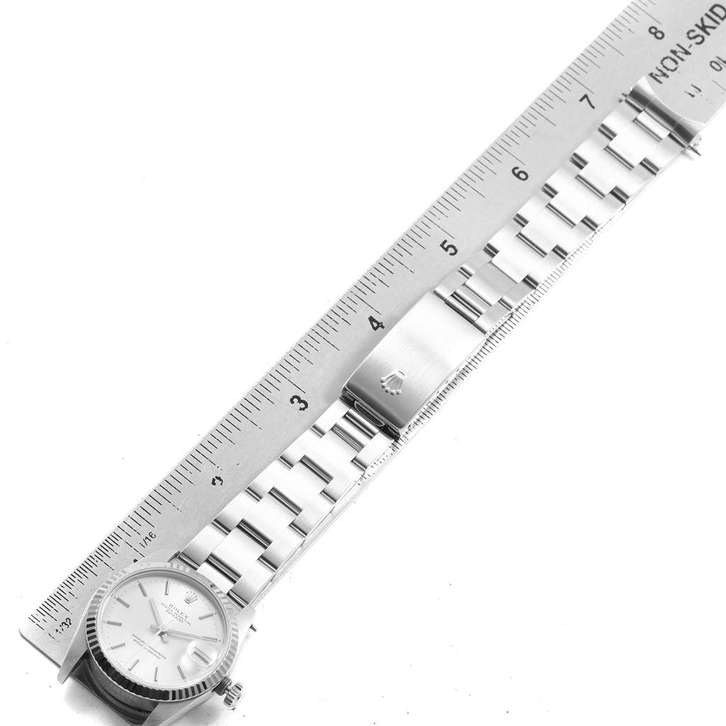 The image shows a top-down view of a Mid-Size Rolex watch, highlighting its face, bracelet, and buckle next to a ruler.