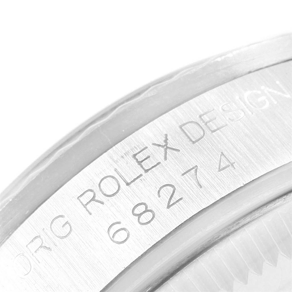 This close-up image of a Rolex Mid-Size 68274 Women
s Stainless Steel Silver Dial 68274 Women
s Stainless Steel Silver Dial model shows the engraved serial number and "ROLEX DESIGN" on the inner bezel.