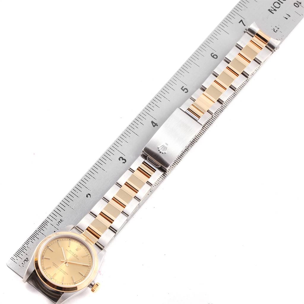 The Rolex Mid-Size 20548 Women
s Steel and Gold (two tone) Champagne Dial 20548 Women
s Steel and Gold (two tone) Champagne Dial watch is shown from a top-down angle, displaying the face, bezel, and bracelet in detail next to a ruler.