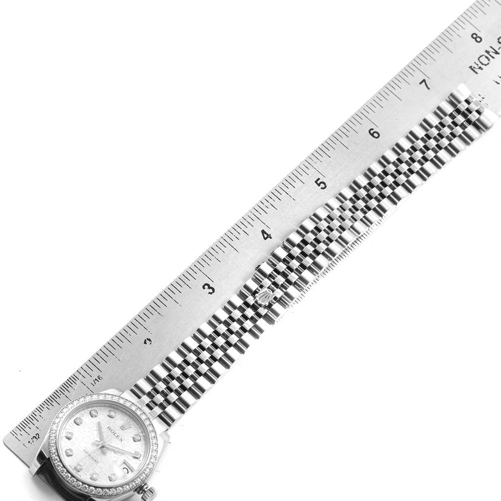 The image shows a Rolex Mid-Size 178384 Women's Stainless Steel Silver Dial 178384 Women's Stainless Steel Silver Dial watch laid flat with its face and bracelet aligned with a ruler for scale.