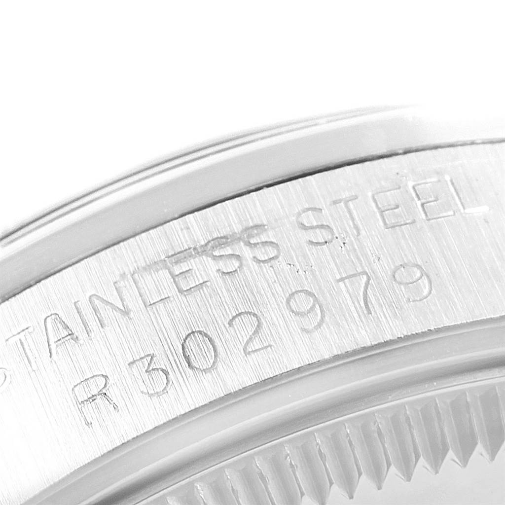 Close-up of the case back inscription and bezel teeth of a Rolex Mid-Size 68240 Women's Stainless Steel Grey Dial 68240 Women's Stainless Steel Grey Dial model watch, showing the serial number and "Stainless Steel."