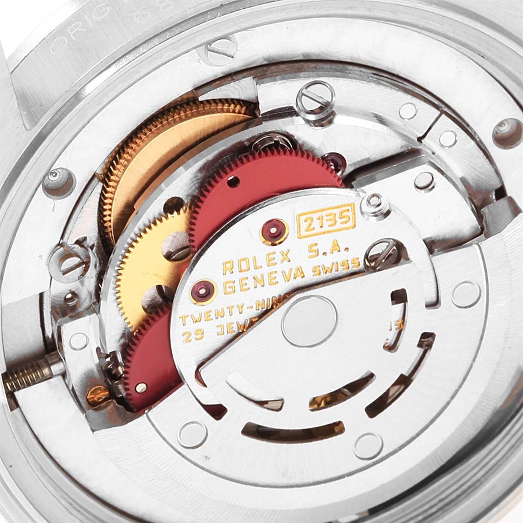 The image shows the internal mechanism of a Mid-Size Rolex watch, highlighting the gears and movement parts.