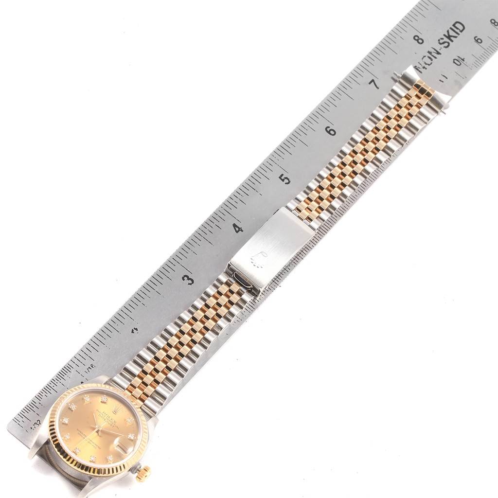 This image shows a Mid-Size Rolex watch with its face and band, placed next to a ruler for size reference.