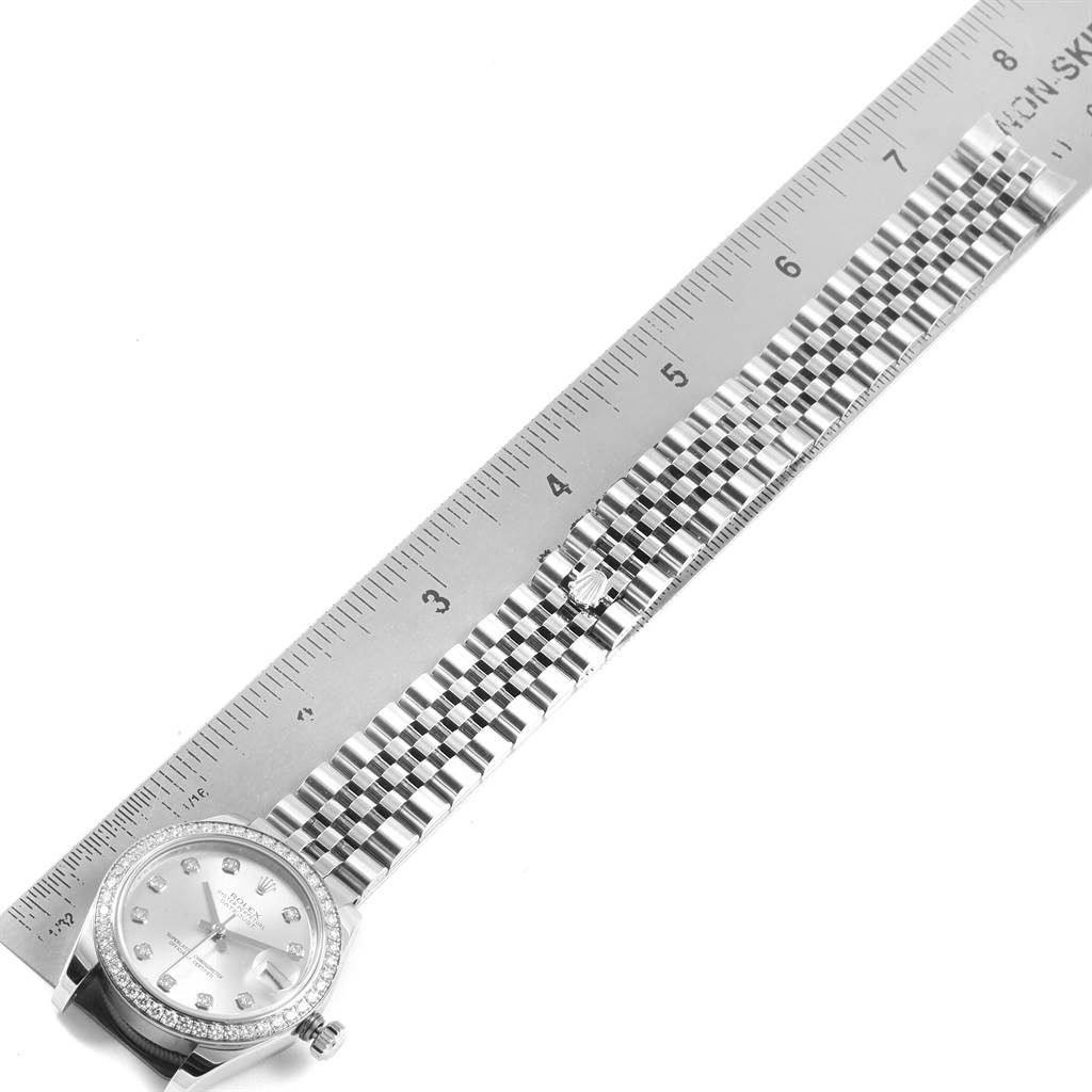 This image shows a top view of a Rolex Mid-Size 178384 Women's Stainless Steel Silver Dial 178384 Women's Stainless Steel Silver Dial model watch, aligning its bracelet and case with a ruler.