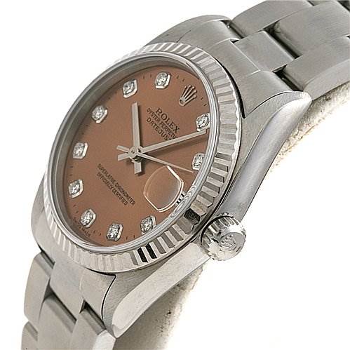 The image shows a Mid-Size Rolex watch with a pink dial, diamond hour markers, a date display, and a stainless steel bracelet at an angled view.
