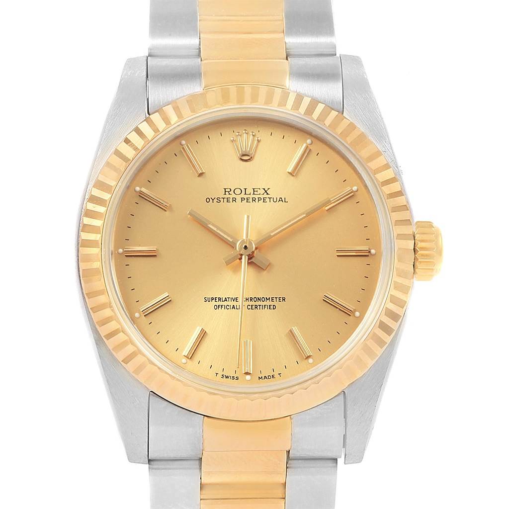 The image shows a frontal view of the Rolex Oyster Perpetual Mid-Size watch, featuring its face, fluted bezel, and part of the bracelet.