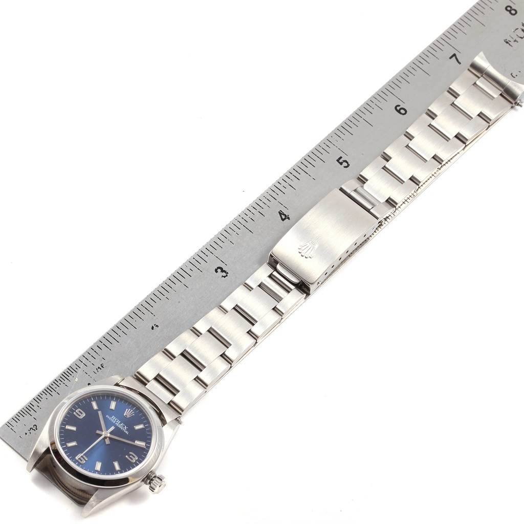 The Rolex Mid-Size 77080 Women's Stainless Steel Blue Dial 77080 Women's Stainless Steel Blue Dial watch is shown in full length, including the face, wristband, and clasp, beside a ruler for size reference.