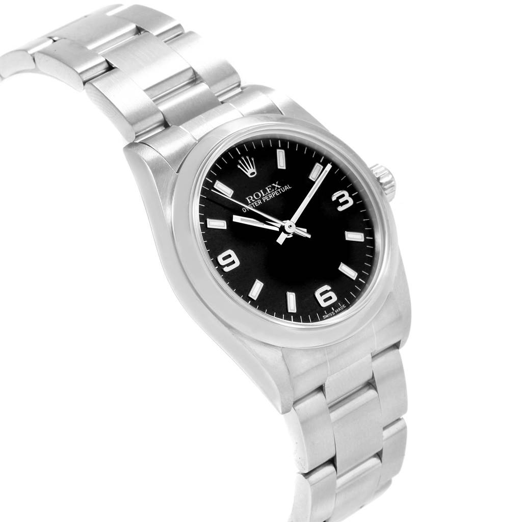 The image shows a Mid-Size Rolex watch with a black dial and stainless steel bracelet, viewed at a three-quarter angle.