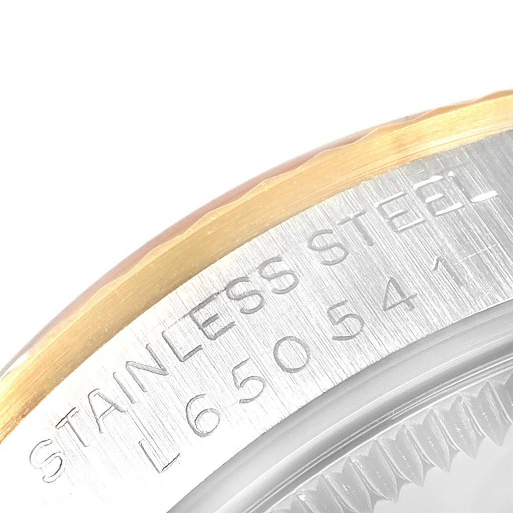 The image shows a close-up of the stainless steel bezel and part of the caseback of a Rolex Mid-Size 68273 Women's Steel and Gold (two tone) Blue Dial 68273 Women's Steel and Gold (two tone) Blue Dial model watch.