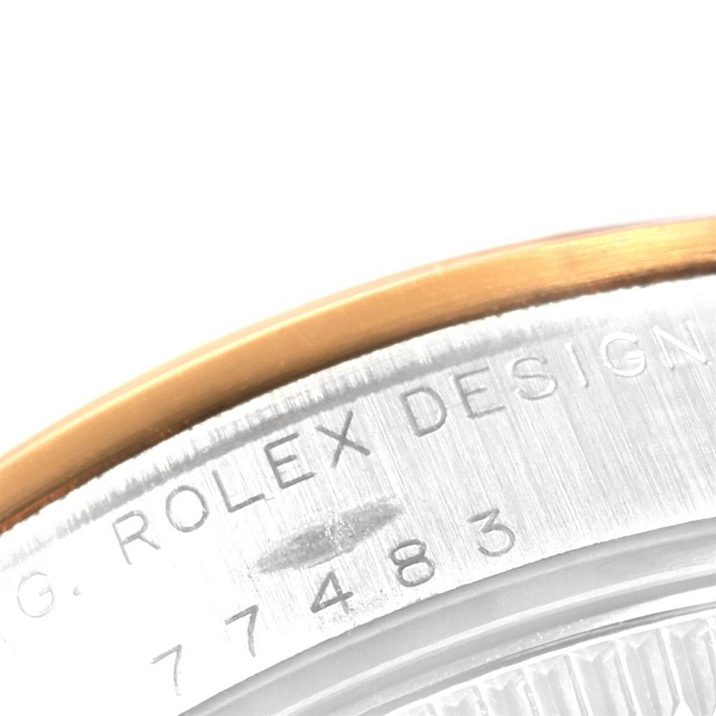 The image shows a close-up of the case back and edge of a Rolex Mid-Size 77483 Women's Steel and Gold (two tone) Grey Dial 77483 Women's Steel and Gold (two tone) Grey Dial model watch, featuring an engraved serial number.