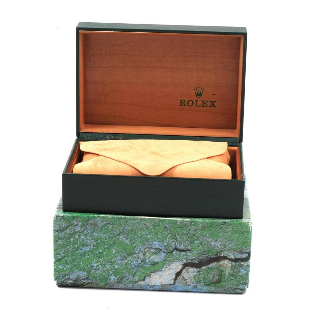 This image shows an open Rolex Mid-Size 77483 Women's Steel and Gold (two tone) Grey Dial 77483 Women's Steel and Gold (two tone) Grey Dial watch box, displaying the inner wooden compartment and a suede pouch.