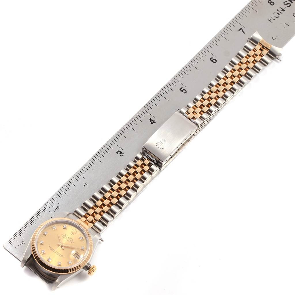 The image shows a top-down view of a Rolex Mid-Size 68273 Women's Steel and Gold (two tone) Champagne Dial 68273 Women's Steel and Gold (two tone) Champagne Dial watch, including the dial, bezel, crown, and bracelet alongside a measuring ruler.