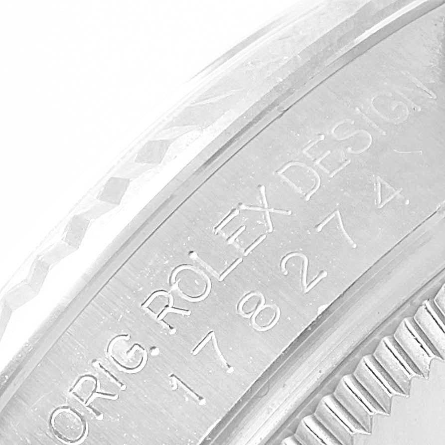 Close-up of the side of a Rolex Mid-Size 178274 Women's Stainless Steel Silver Dial 178274 Women's Stainless Steel Silver Dial watch showing the engraved serial number and part of the bezel.