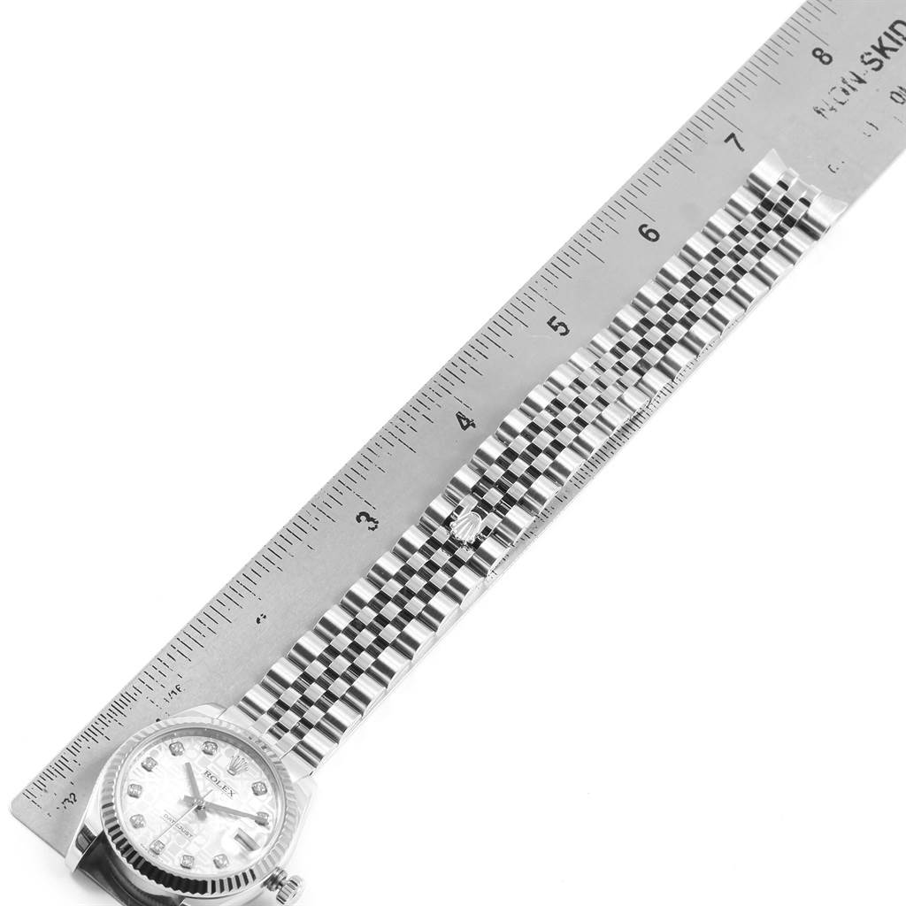 A Rolex Mid-Size 178274 Women's Stainless Steel Silver Dial 178274 Women's Stainless Steel Silver Dial watch is shown laying flat with its bracelet extended alongside a ruler for measurement.