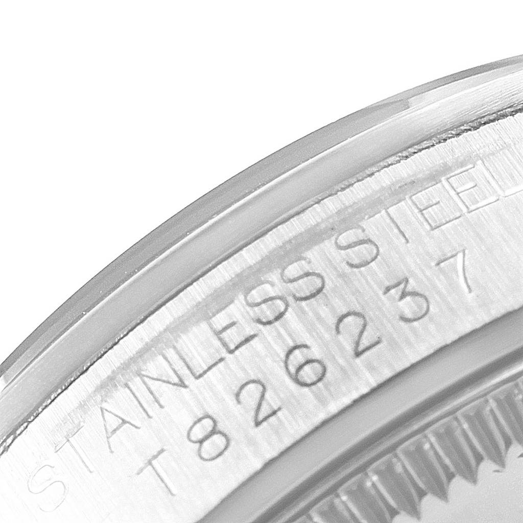 This close-up image shows the engraved serial number and "STAINLESS STEEL" text on the side of a Rolex Mid-Size 67480 Women's Stainless Steel Pink Dial 67480 Women's Stainless Steel Pink Dial model watch case.